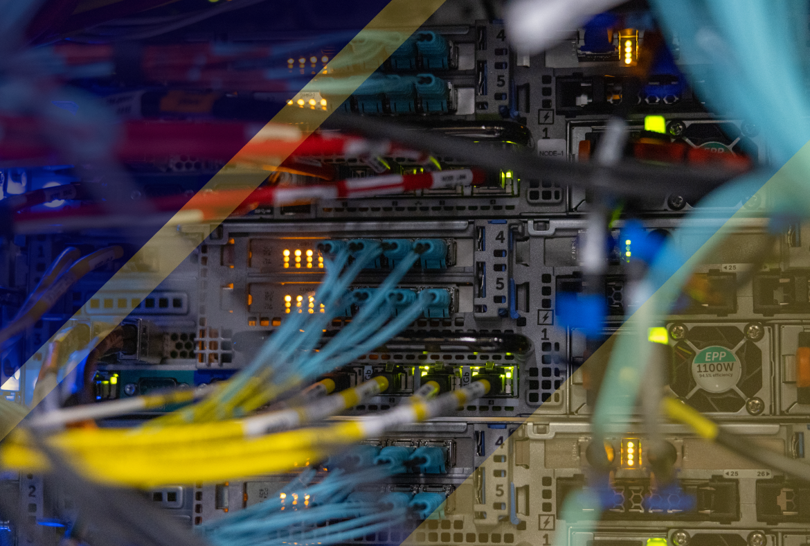 Close-up of server hardware with fiber and network cables connected to ports, amber and green status lights glowing across stacked rack equipment.