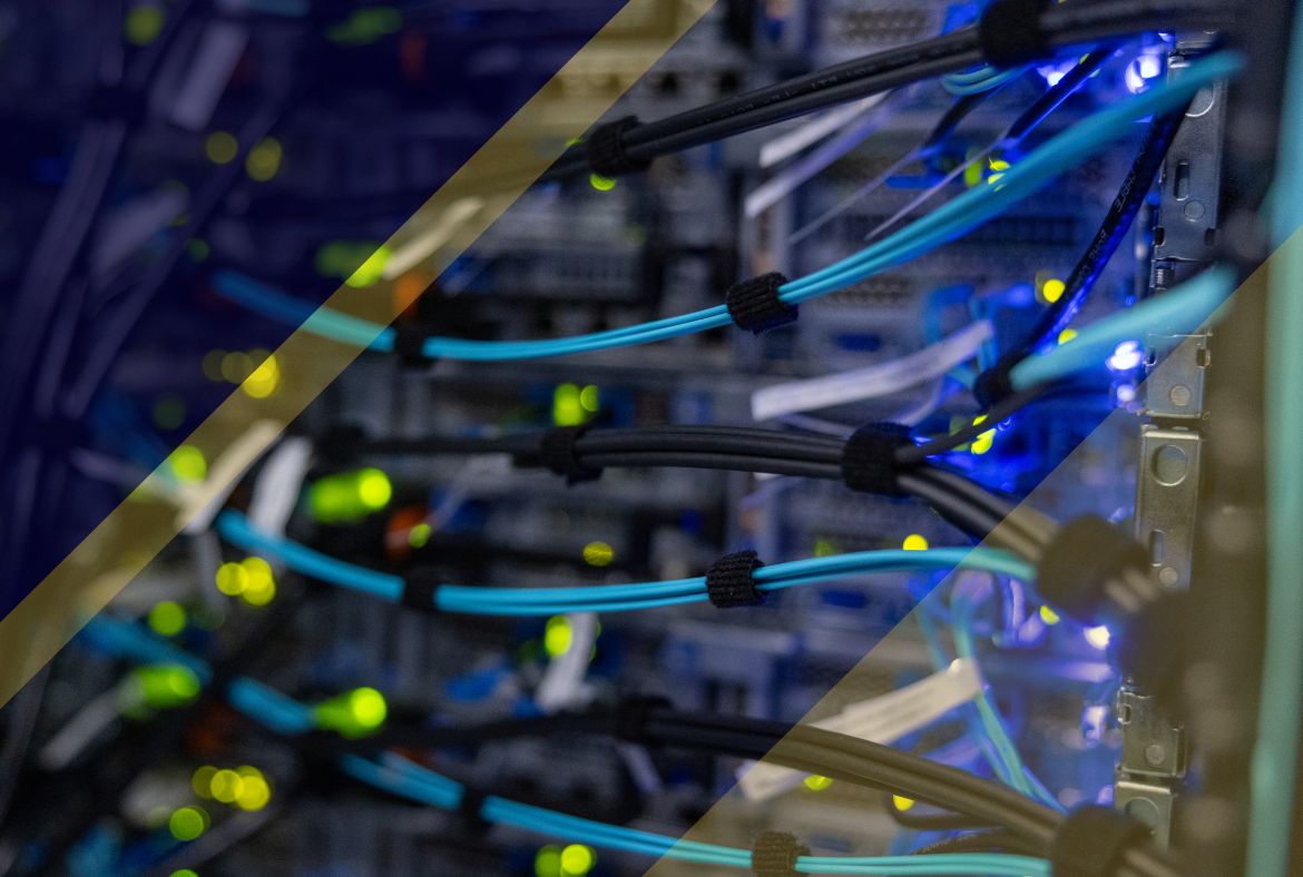 Close-up of servers in a data center with blue and black network cables connected, green and blue status lights glowing across the equipment.