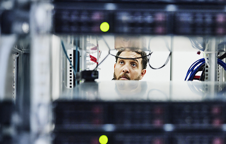 Man looking through a data center rack
