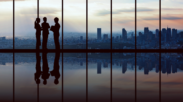 two silhouettes in the window with the skyline behind them