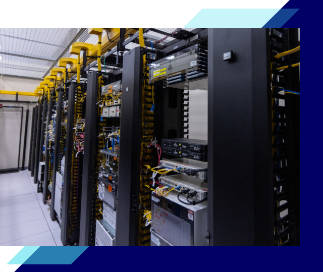 Row of data center server racks with network equipment and bundled cables inside a clean, well-lit facility.