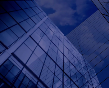 Upward view of modern glass office buildings with reflective blue windows against a cloudy sky