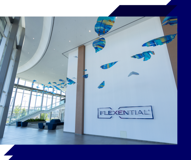 Modern lobby with glass walls, staircase, and blue hanging art installation above a Flexential wall sign in a bright, open interior space