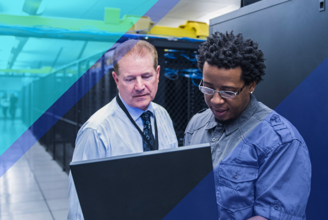 Two professionals reviewing data on a monitor in a data center aisle, with server racks and blue geometric overlays in the background.