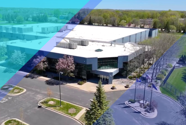 Aerial view of a large colocation data center campus with surrounding trees, parking areas, and blue geometric graphic overlays.