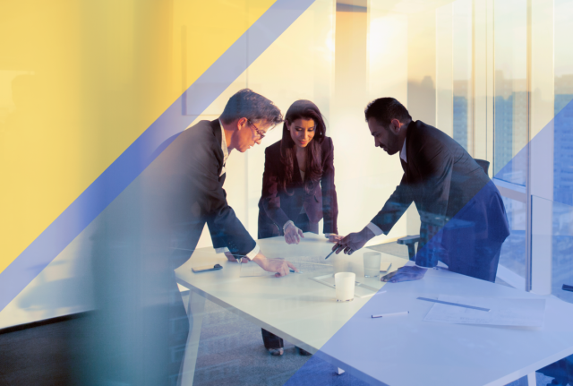 Three people collaborating around a conference table in a modern office, reviewing documents with blue and gold geometric overlays.