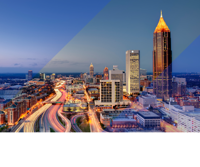 Atlanta skyline at dusk with illuminated skyscrapers, busy highway light trails, and blue geometric overlays across the cityscape.